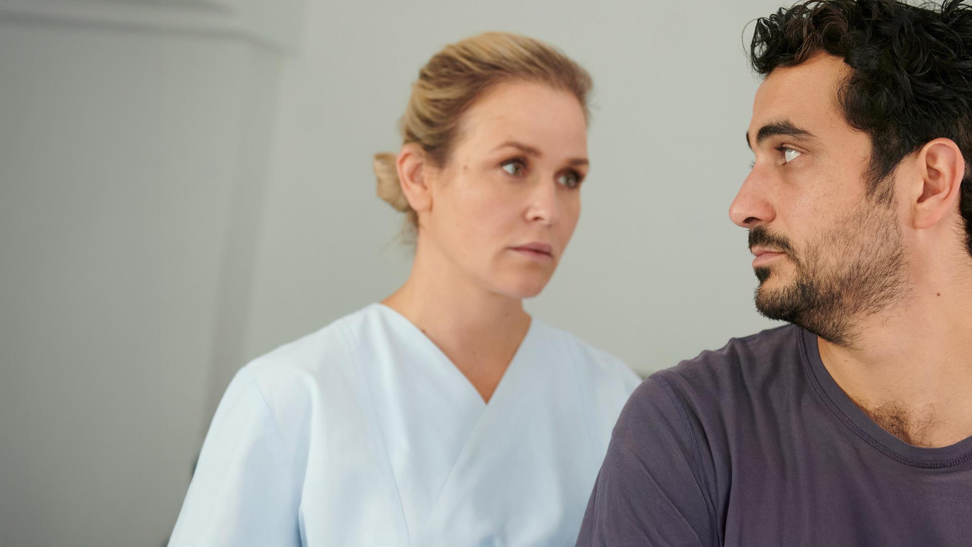 Ben Tewolde (Timo Fakhravar) schaut Lena Lorenz (Judith Hoersch) an, die in Klinikkleidung hinter ihm steht.