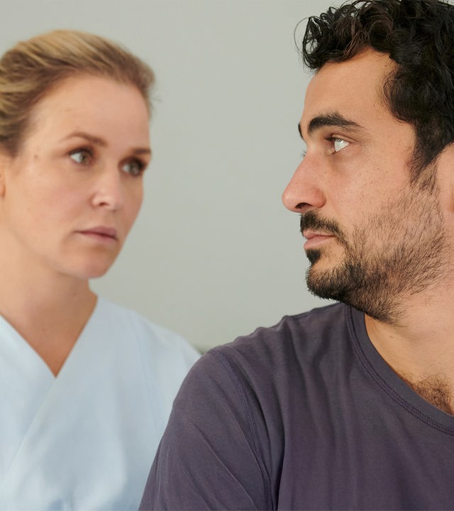 Ben Tewolde (Timo Fakhravar) schaut Lena Lorenz (Judith Hoersch) an, die in Klinikkleidung hinter ihm steht.