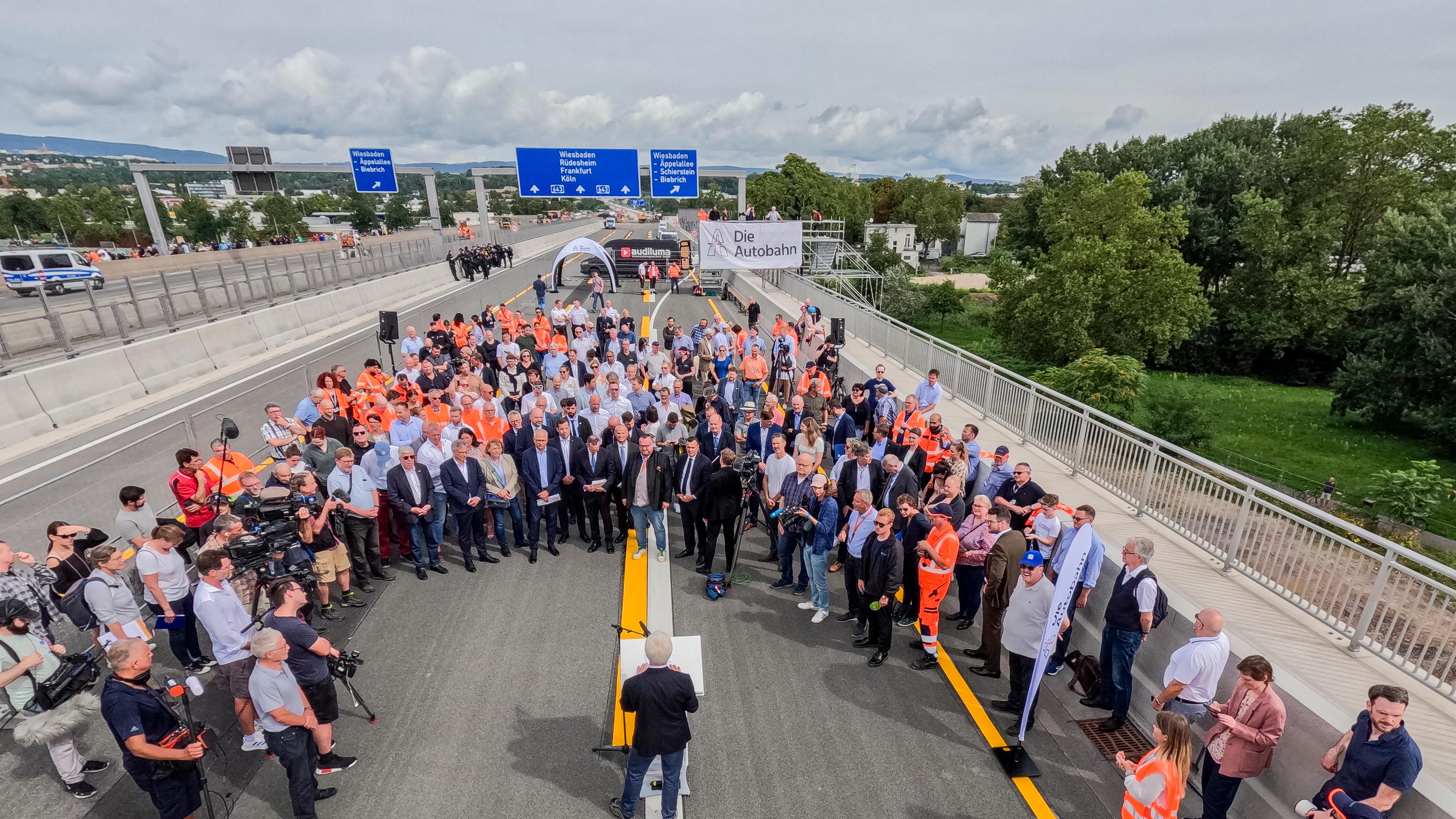 Politiker und Gäste stehen vor der symbolische Verkehrsfreigabe auf der Schiersteiner Brücke.