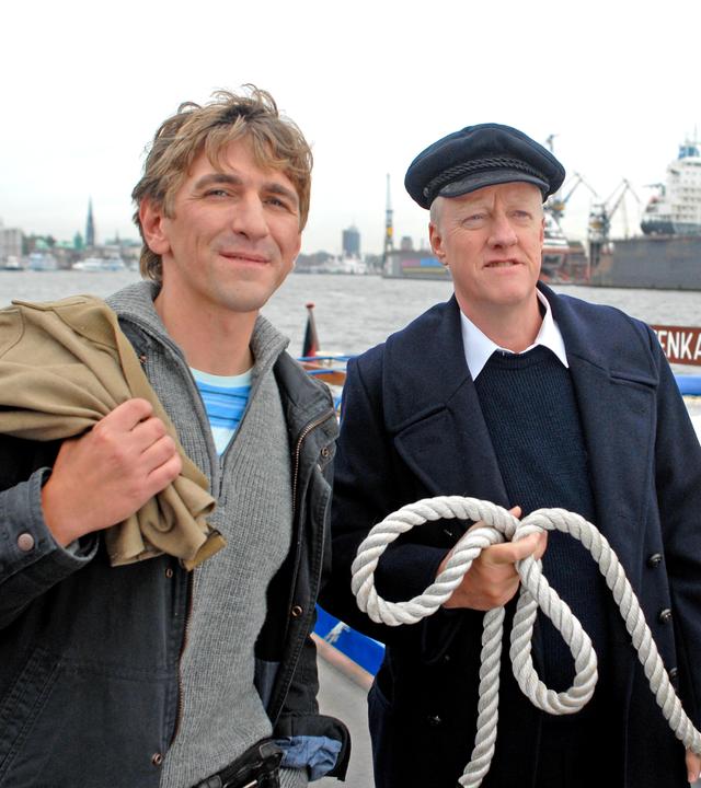 Fritz Fuchs und der Decksmann stehen am Hafen.