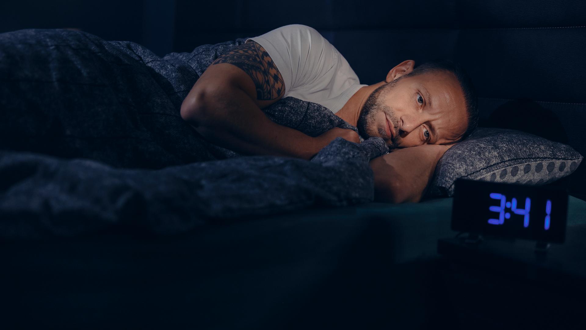 Waldemar liegt wach im Bett. Neben ihm steht ein Wecker, die Uhrzeit zeigt 3:41h nachts an. 