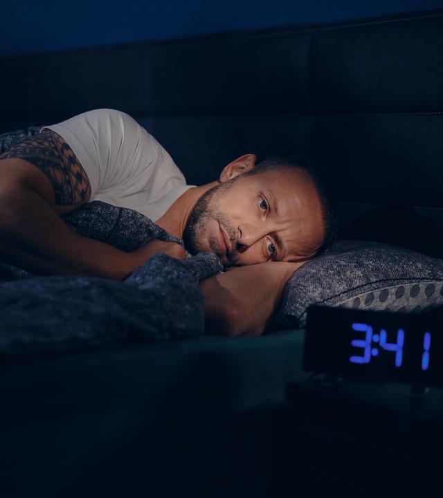 Waldemar liegt wach im Bett. Neben ihm steht ein Wecker, die Uhrzeit zeigt 3:41h nachts an. 