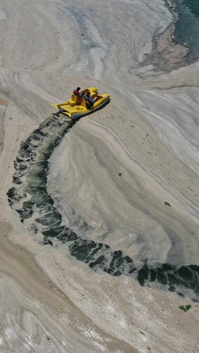 Boot fährt einen Kreis durch den Meeresschleim und zieht dabei eine Spur