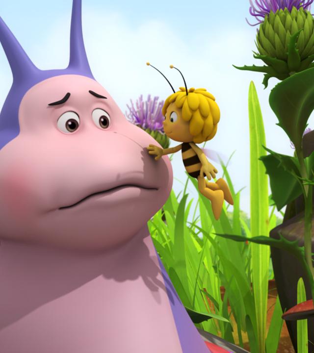 Maja tröstet Schnecke Heinz und fasst ihm an die Wange.