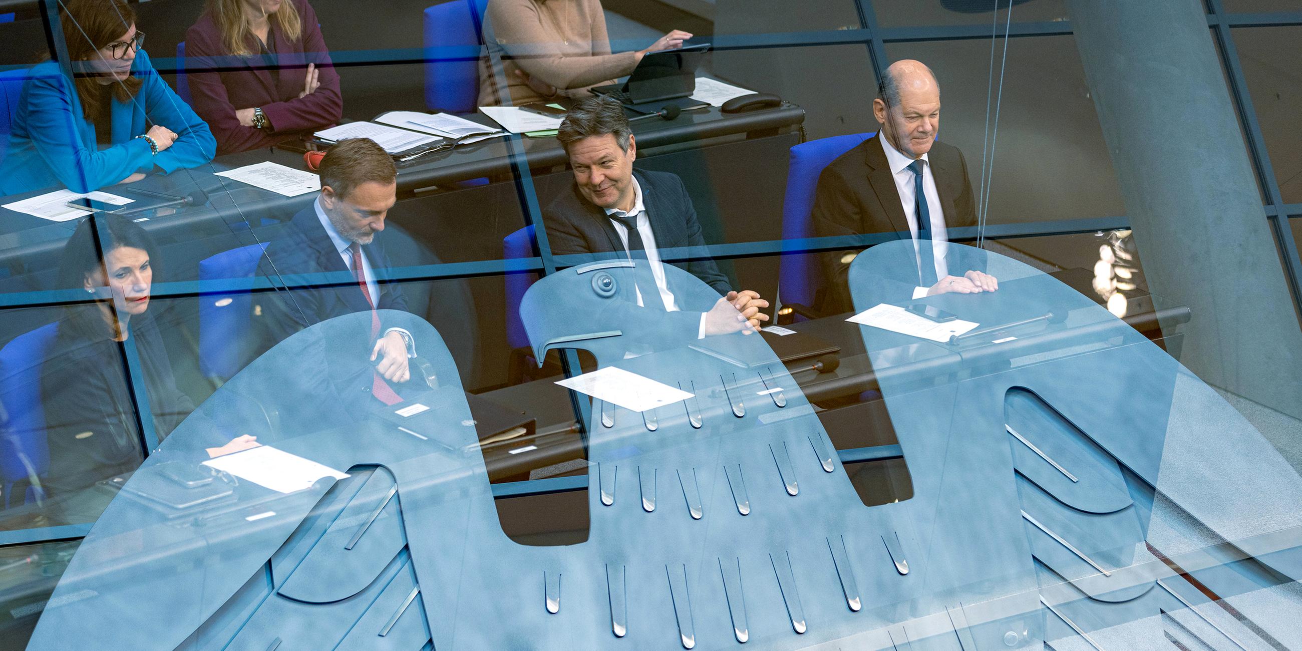 Christian Lindner, Robert Habeck und Olaf Scholz sitzen nebeneinander im Plenarsaal (Doppelbelichtung mit Bundesadler)