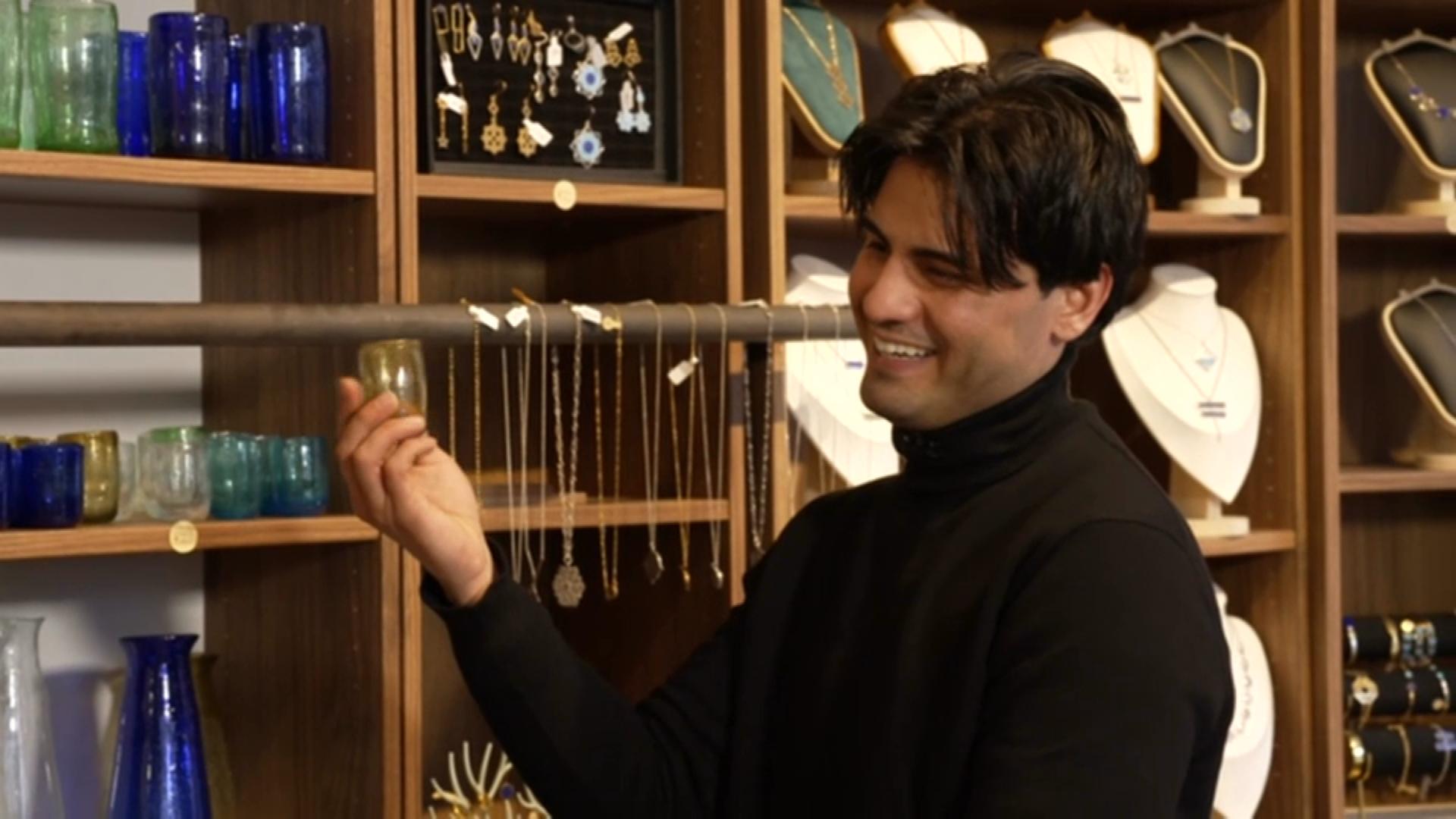 Hasib Azizi in seinem Schmuckgeschäft - im Hintergrund diverse Schmuckstücke in Regalen.