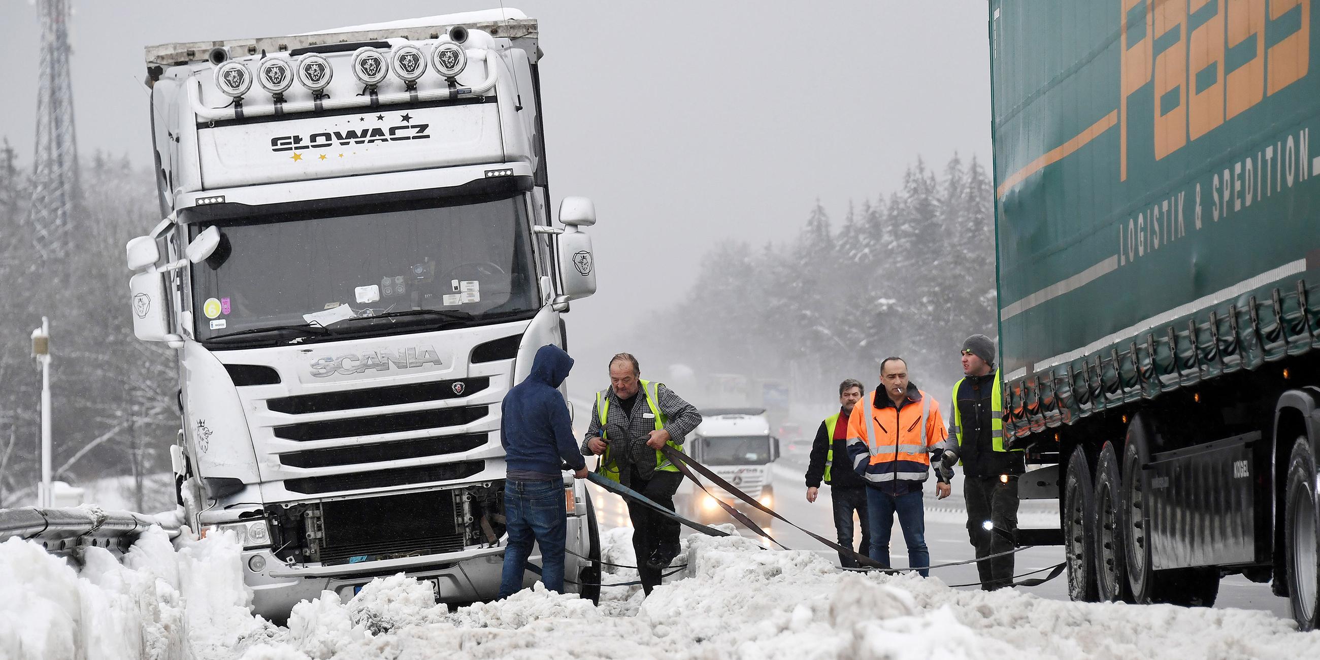 Lkw-Fahrer versuchen auf der A8 bei Holzkirchen ihre feststeckenden Fahrzeuge zu befreien.