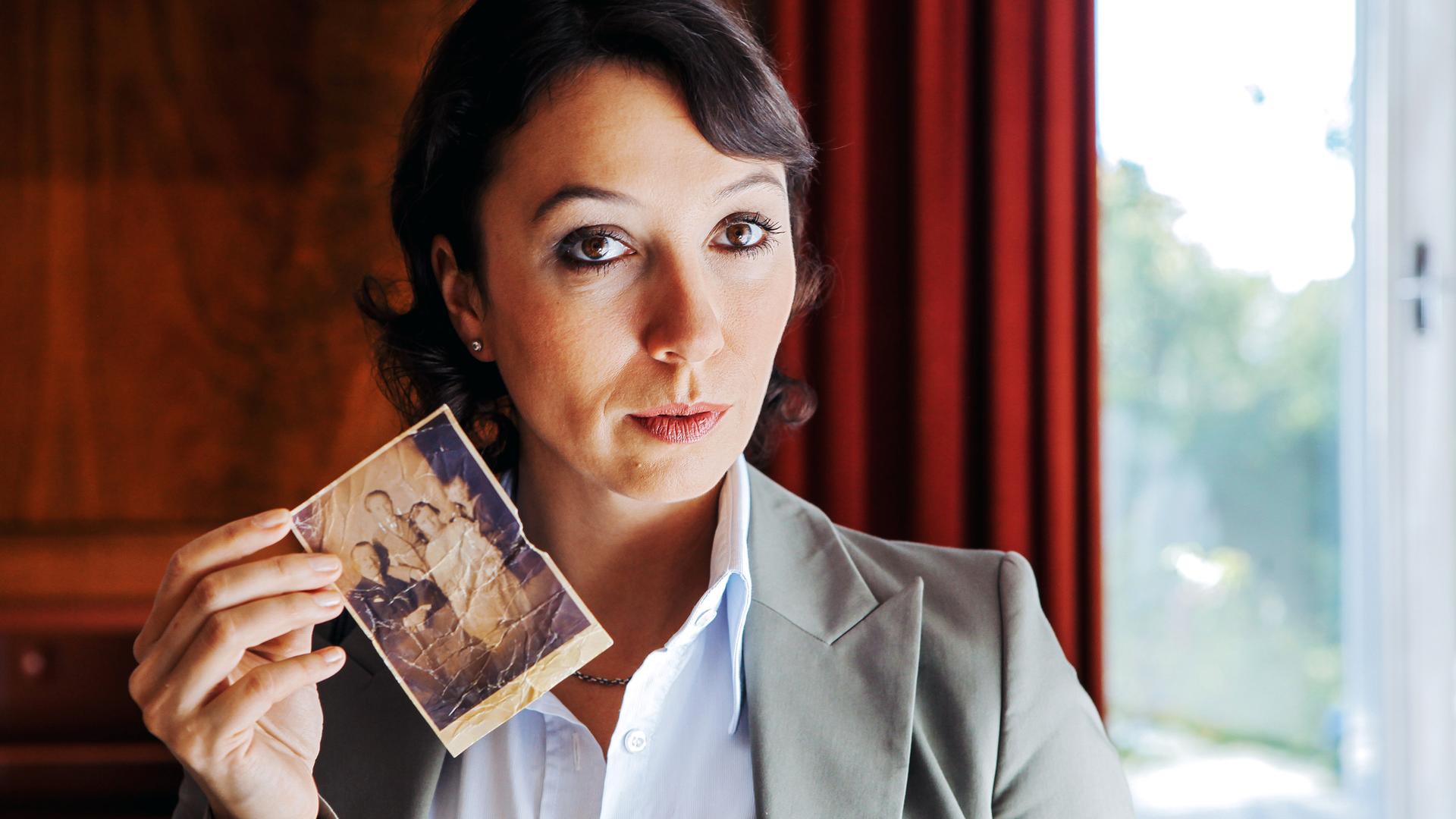 eine frau zeigt ein altes foto