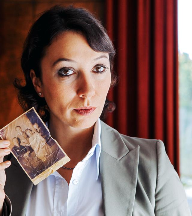eine frau zeigt ein altes foto