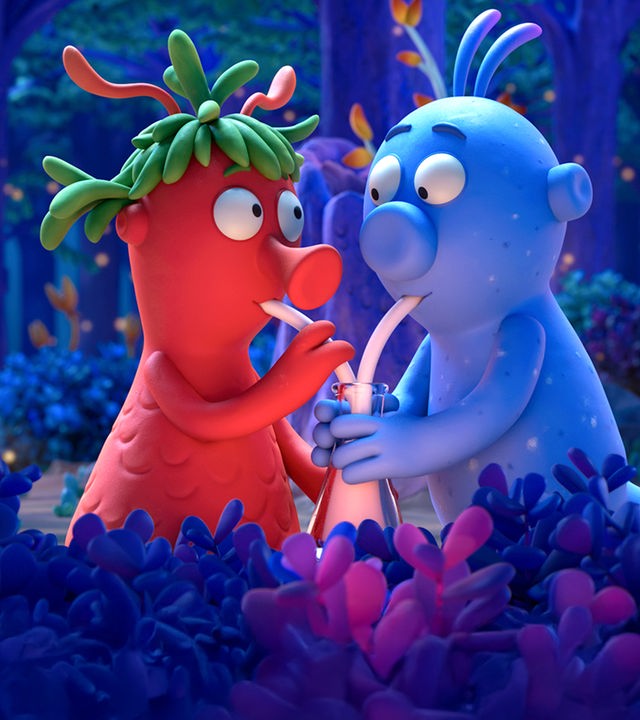 Die Schnetts und die Schmoos: Die rote Grete und der blaue Bernd trinken jeweils mit einem eigenen Strohhalm gemeinsam aus einem Glas. Im Hintergrund ist dunkelblauer Wald zu sehen.