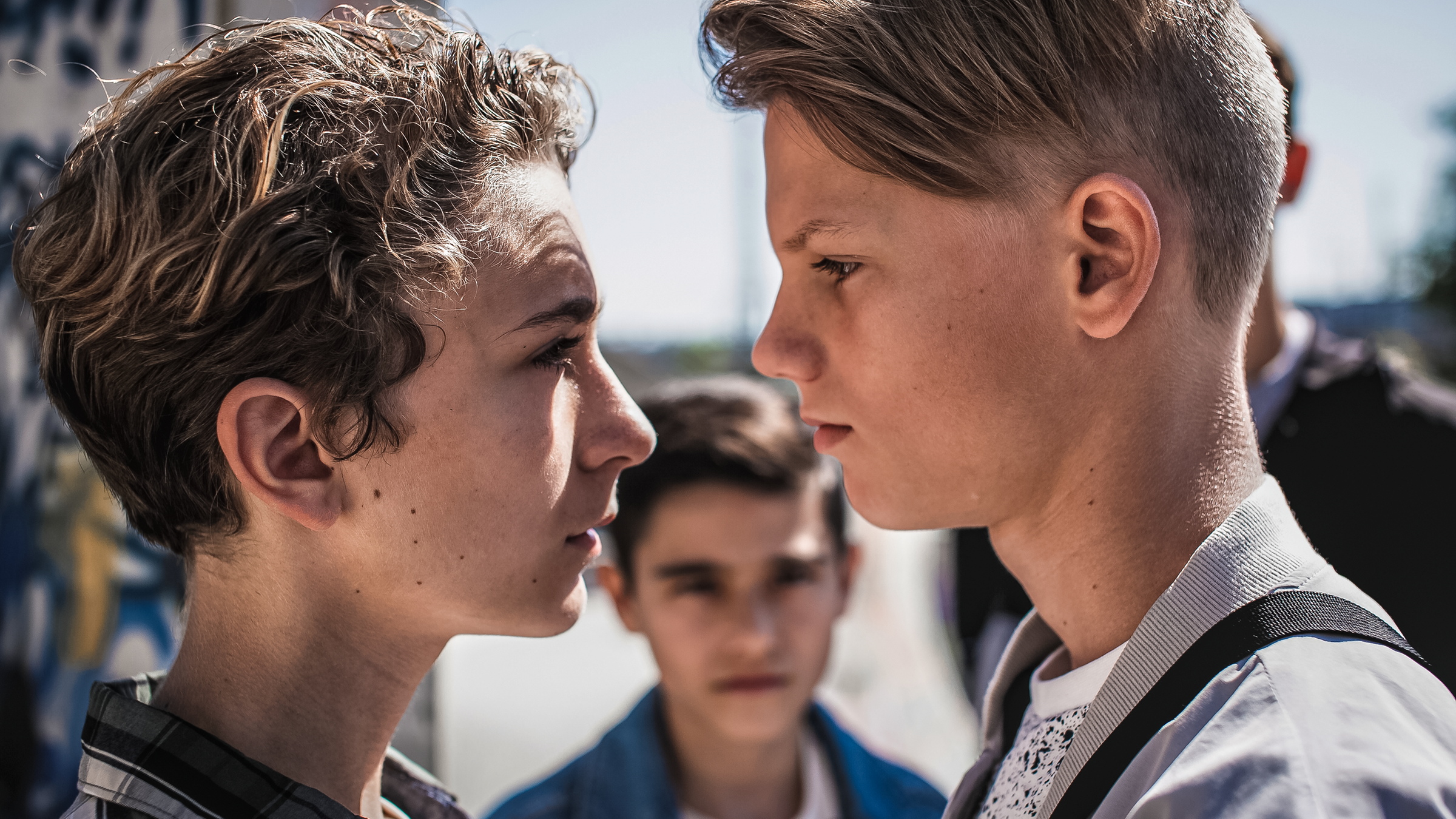 Benny und Lennart stehen sich bedrohlich gegenüber. Im Hintergrund steht Hamid und schaut zu.