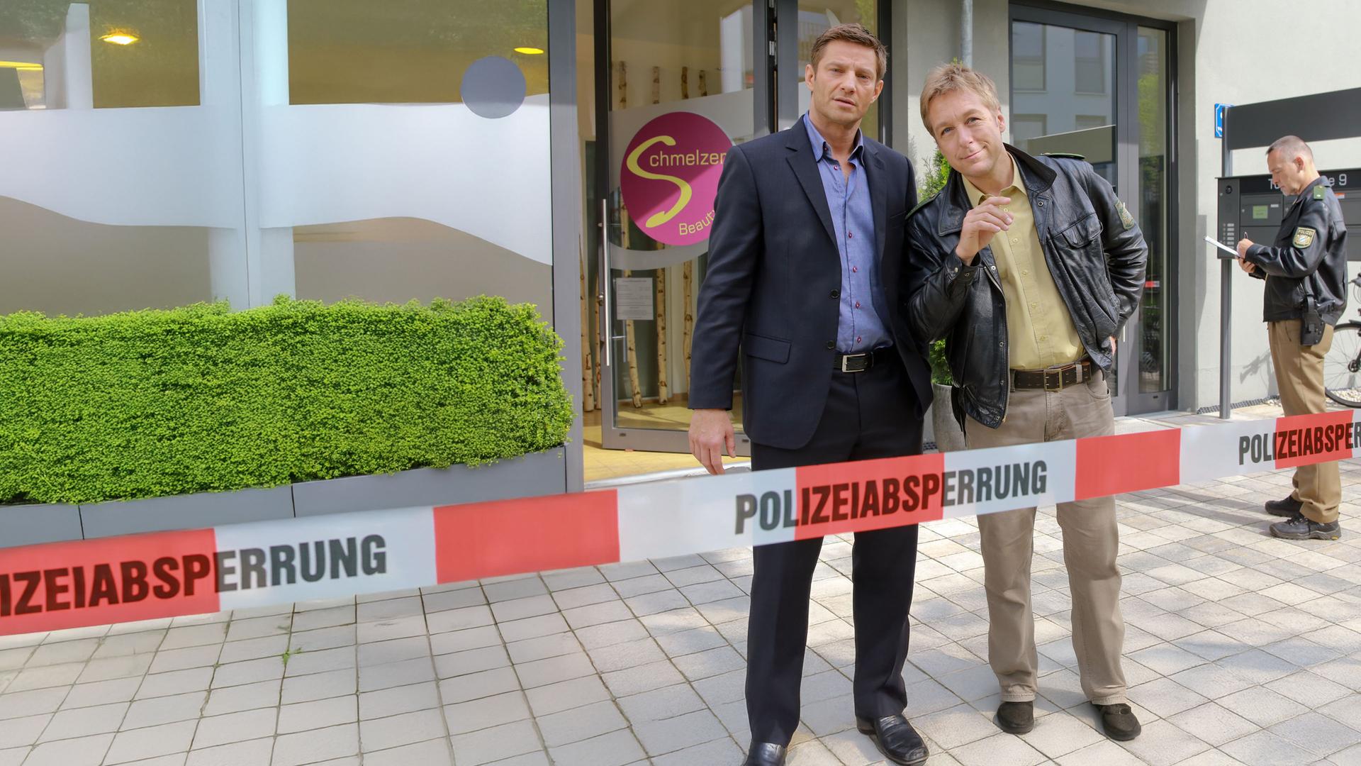 "Die Rosenheim-Cops - Schönheit hat ihren Preis": Kommissar Hansen (Igor Jeftić) und Polizist Mohr (Max Müller) stehen vor einem Schönheitssalon.