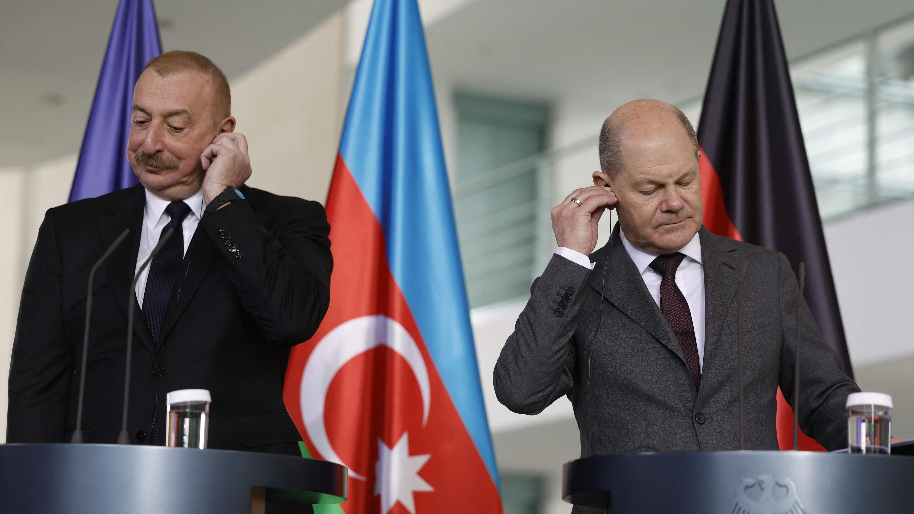 German Chancellor Olaf Scholz (R) and Azerbaijan's President Heydar Aliyev adjust their headphones at the beginning of a press conference after talks at the Chancellery in Berlin, Germany on April 26, 2024.