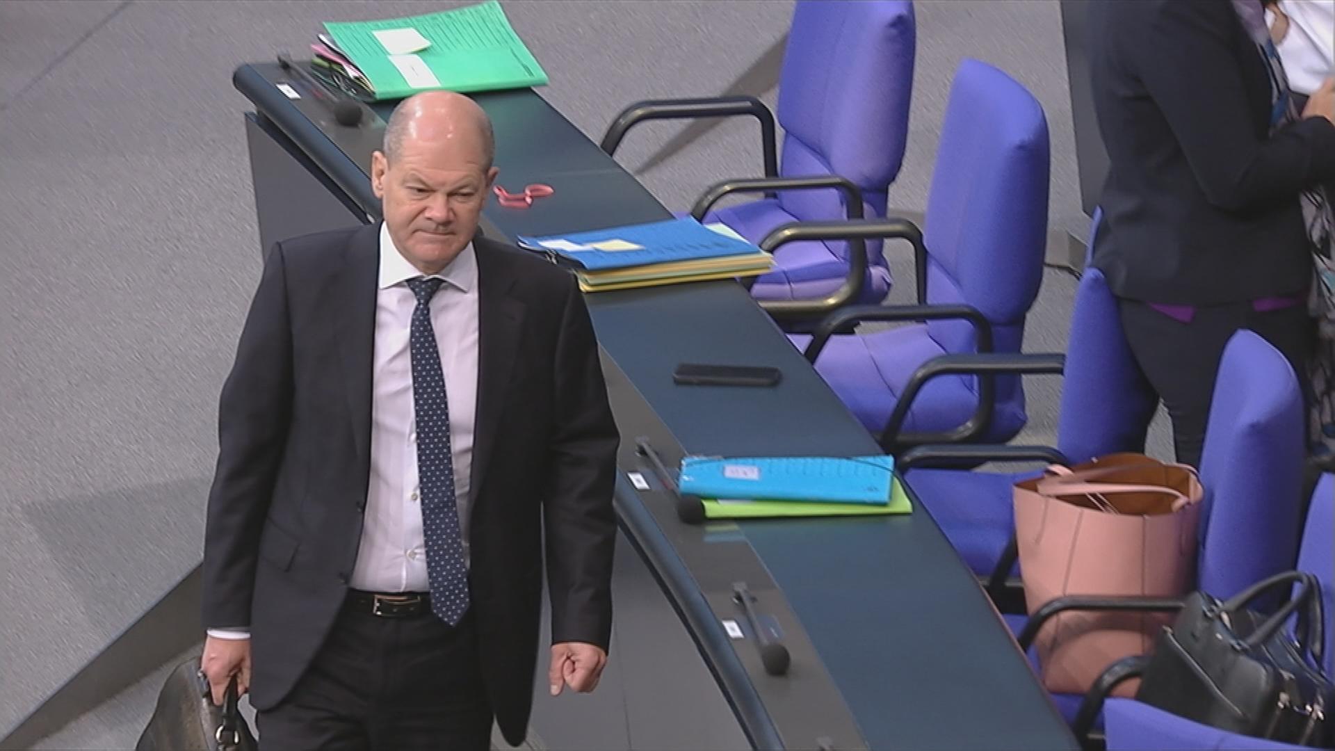 Kanzler Olaf Scholz kommt im Bundestag-Sitzungssaal an.