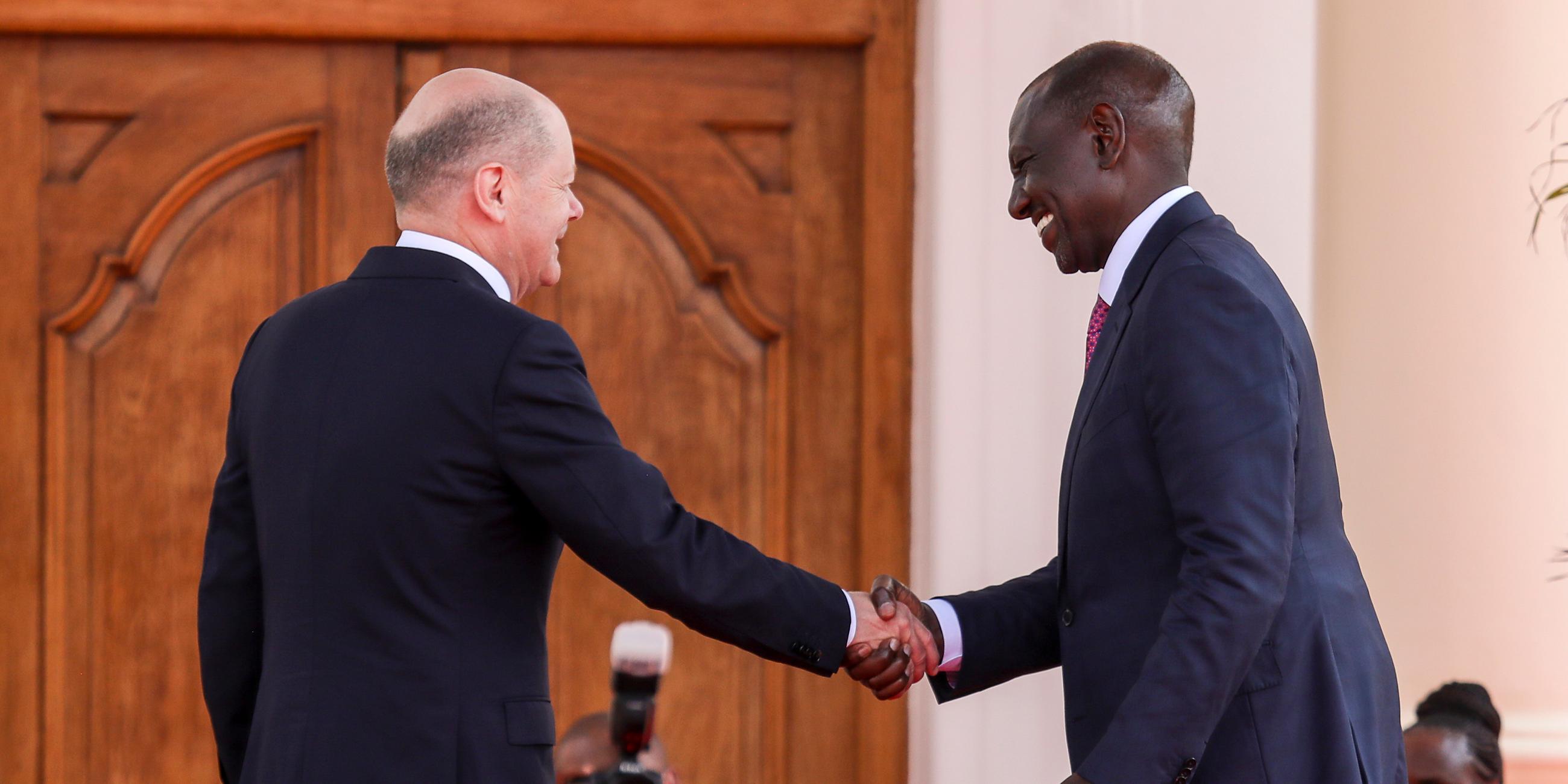 Bundeskanzler Scholz und Kenias Präsident Ruto reichen sich nach einer gemeinsamen Pressekonferenz die Hand