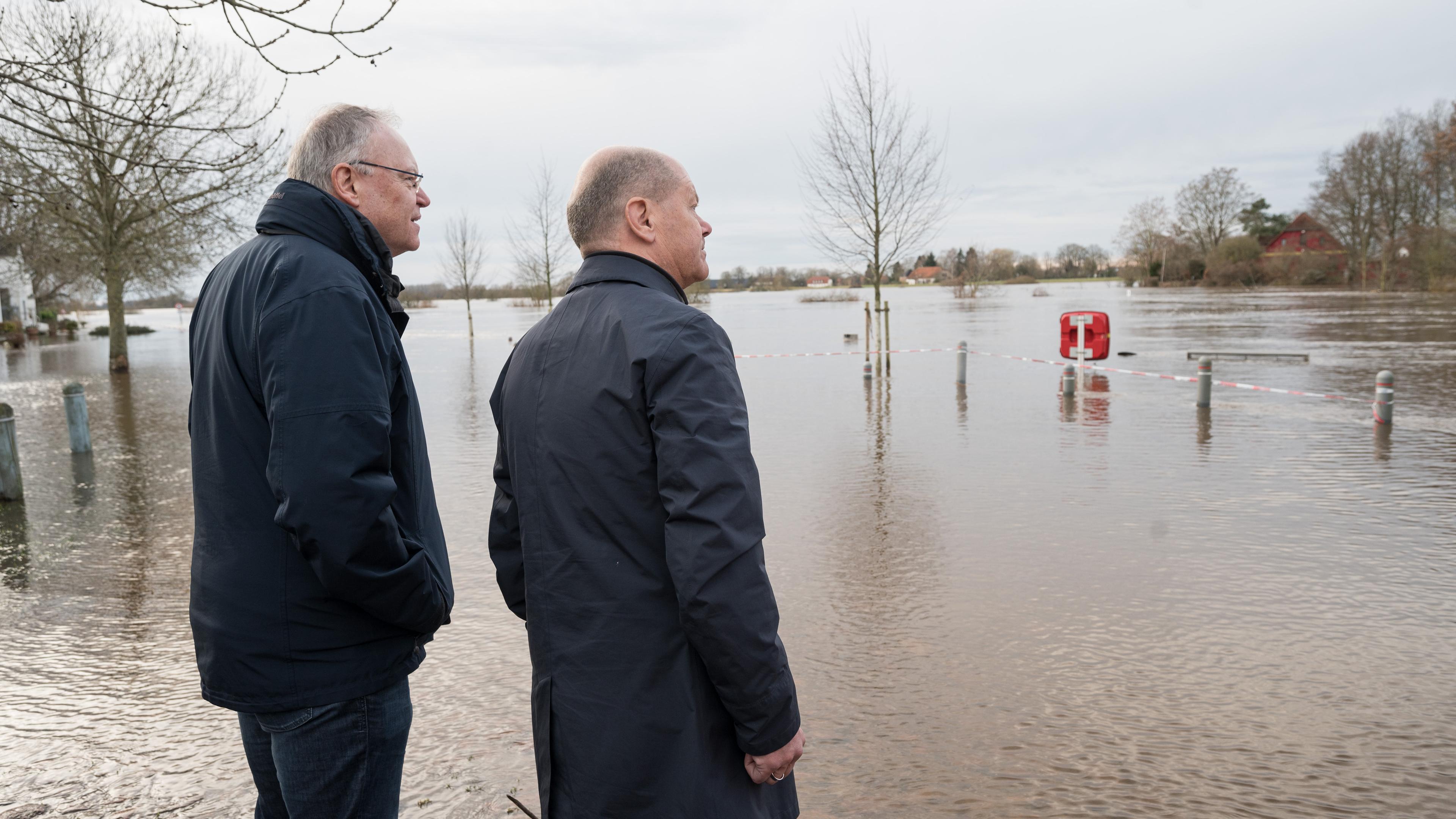 Niedersachsen, Verden: Bundeskanzler Olaf Scholz (SPD, r) und Stephan Weil (SPD), Ministerpräsident von Niedersachsen, stehen an einem überfluteten Gebiet in Verden/Aller in Niedersachsen.