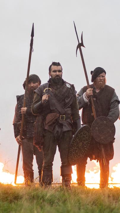 "Schottland - Kampf der Clans: Alte Feinde": Eine Gruppe von schottischen Kriegern mit Speeren. Im Hintergrund Flammen.