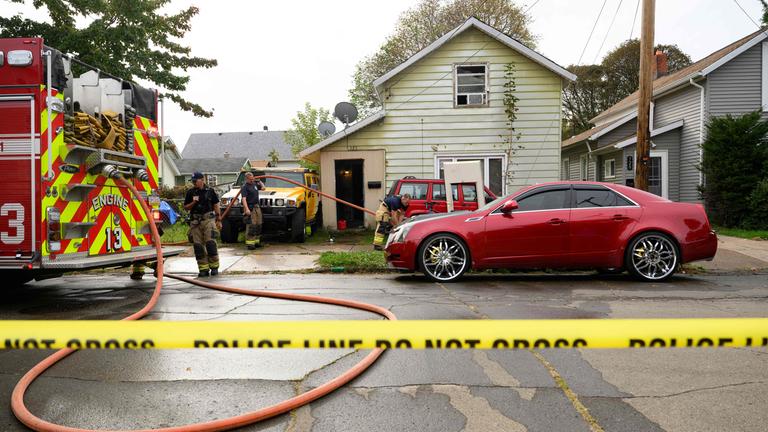 Feuerwehrleute entfernen Blutspuren vor dem Haus in Erie, Pennsylvania in dem am 10.10.2026 neun Mitglieder einer Familie bei einem mutmaßlichen Familienstreit ums Leben kamen.