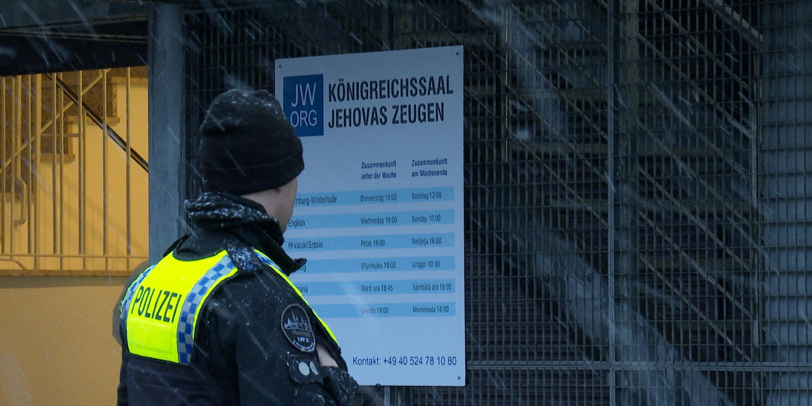 Hamburg: Ein Polizist steht vor einem Gebäude der Zeugen Jehovas in Hamburg.