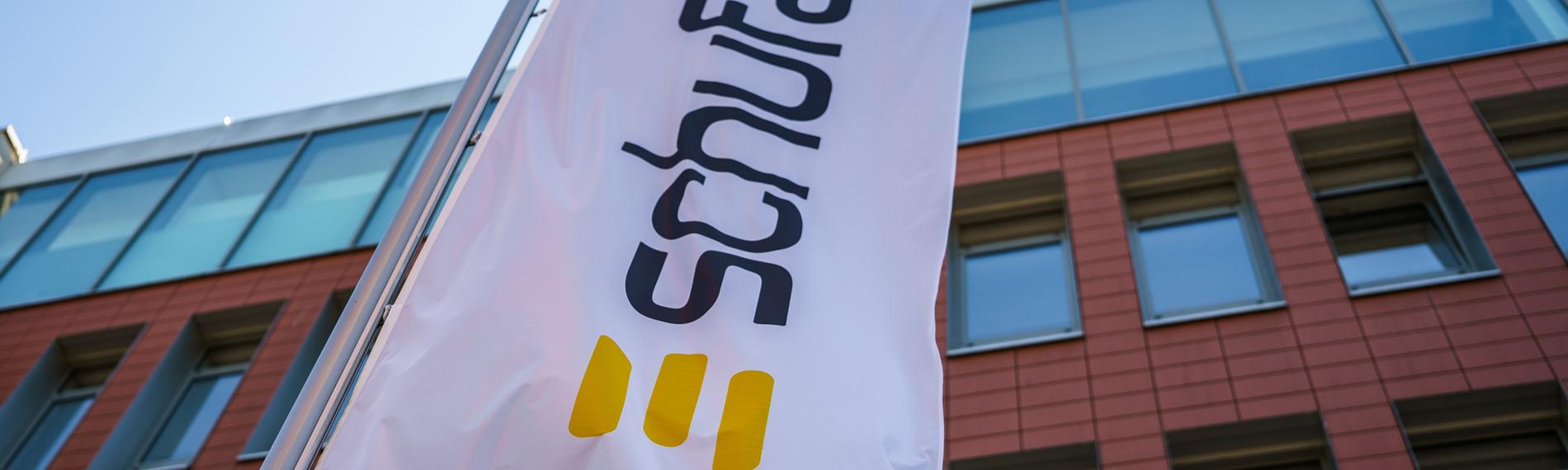Eine Flagge mit dem Firmenlogo flattert vor dem Geschäftssitz der Schufa in der Wiesbaden. 