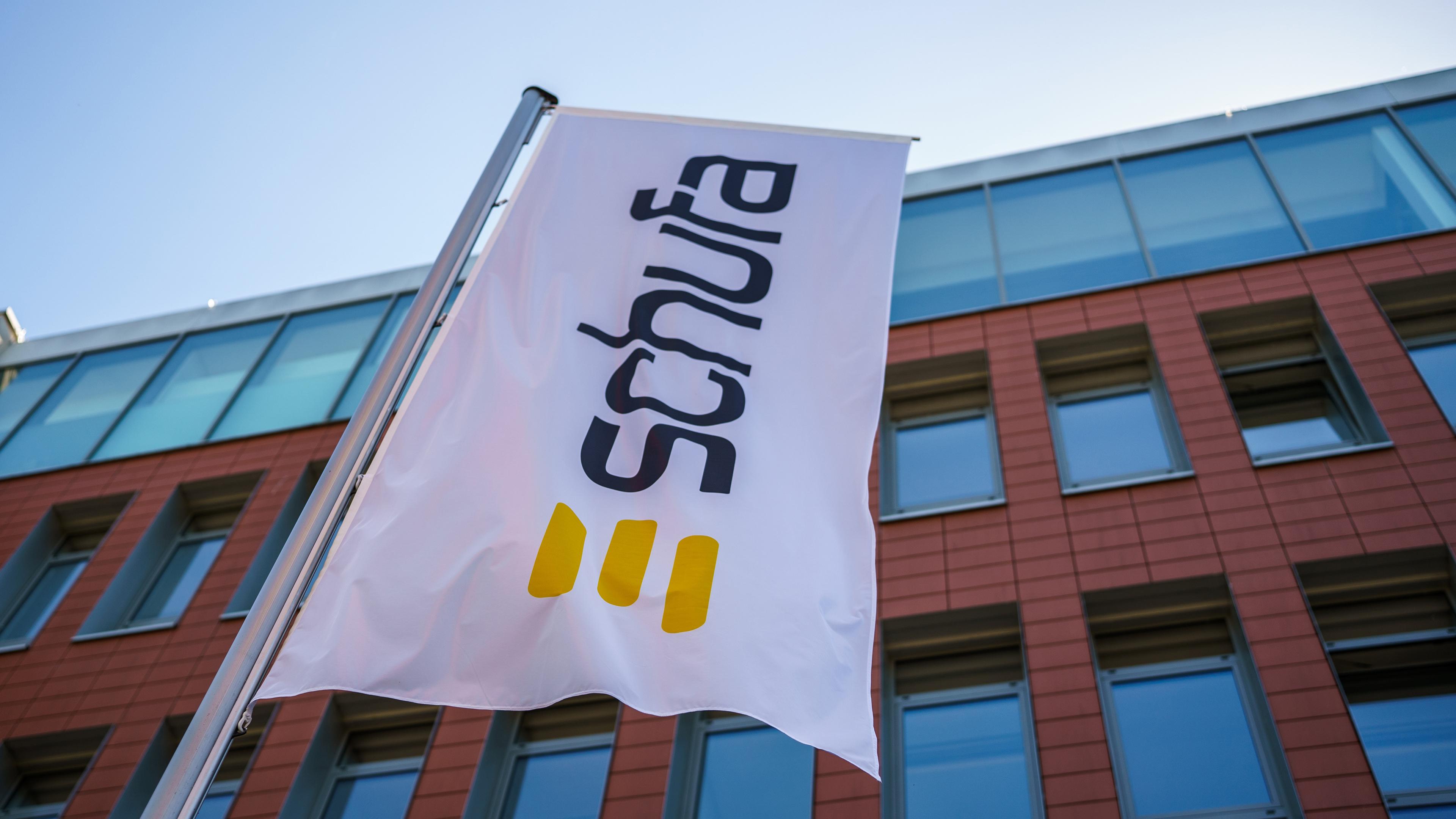 Eine Flagge mit dem Firmenlogo flattert vor dem Geschäftssitz der Schufa in der Wiesbaden. 