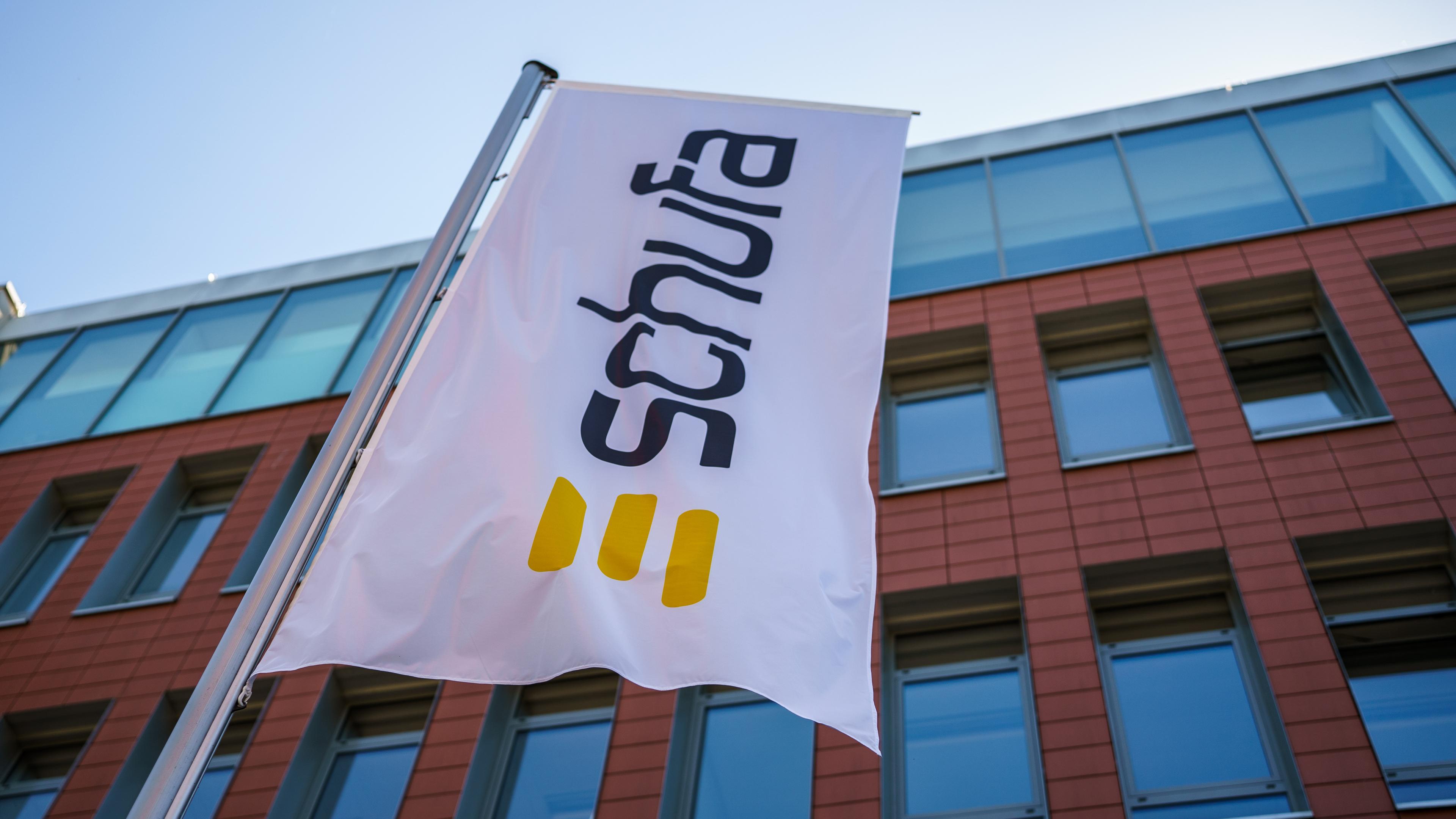 Eine Flagge mit dem Firmenlogo flattert vor dem Geschäftssitz der Schufa in Wiesbaden.