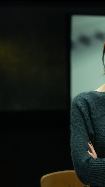 Montage: Paulina Krasa steht vor einem Hintergrund mit einem großen weißen Fingerabdruck auf einer gründen Wand.