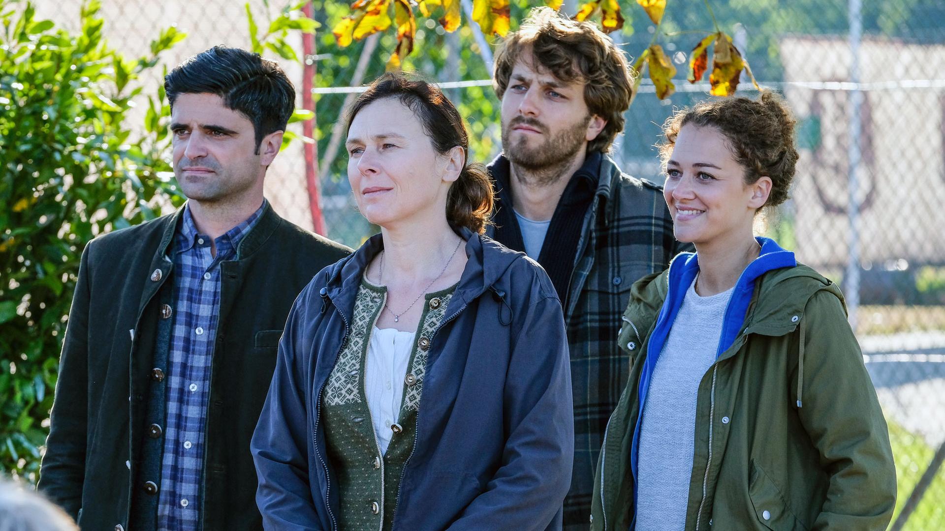 "Tonio & Julia: Schulden und Sühne": Im Freien stehen Tonio Niederegger (Maximilian Grill), Heike Sager (Bettina Mittendorfer), Guido Bender (Frederik Götz) und Julia Schindel (Oona Devi Liebich) dicht beieinander und blicken in die gleiche Richtung. Julia lächelt.