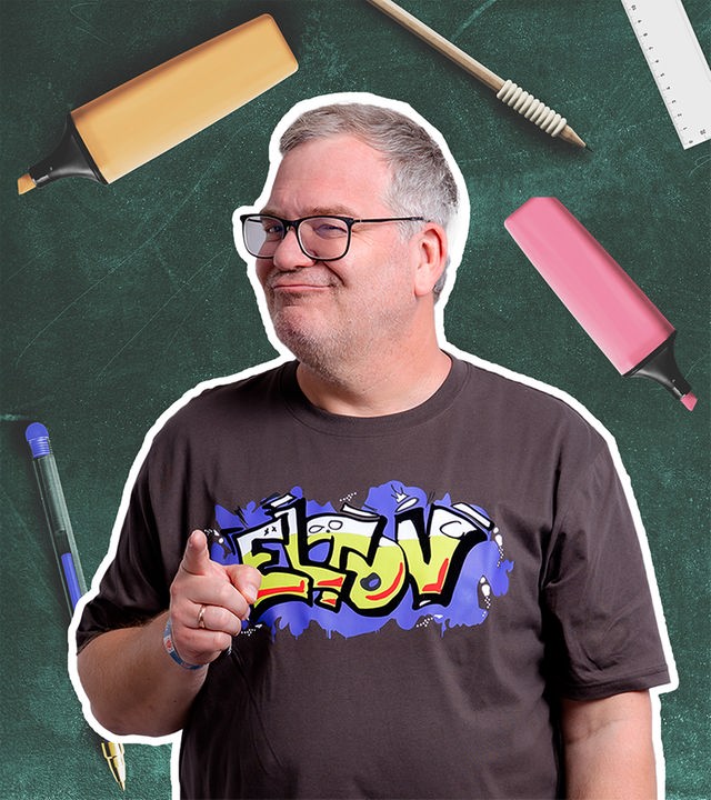 Moderator Elton zeigt vor einer grünen Schultafel nach vorn. Darauf stehen „1 + 2 = 3“ und „Elton is cool“.