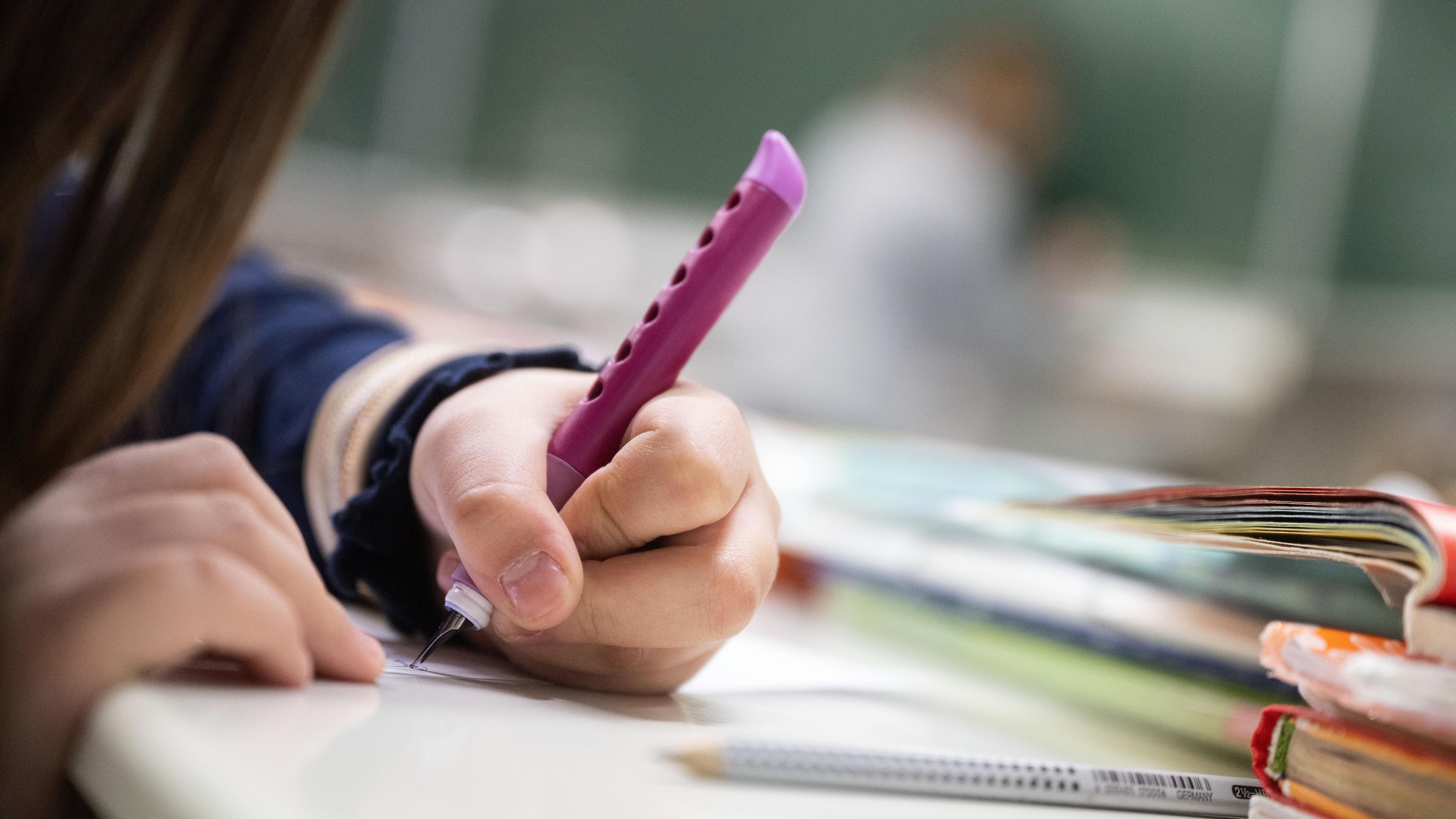 Eine Schülerin sitzt im Klassenzimmer und schreibt, aufgenommen am 17.01.2023 in Suttgart