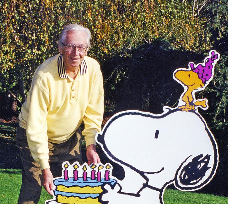 Charles M. Schulz Schöpfer der berühmten Peanuts-Figuren, steht neben Aufstellern, die Hund Snoopy und den kleinen gelben Vogel Woodstock darstellen