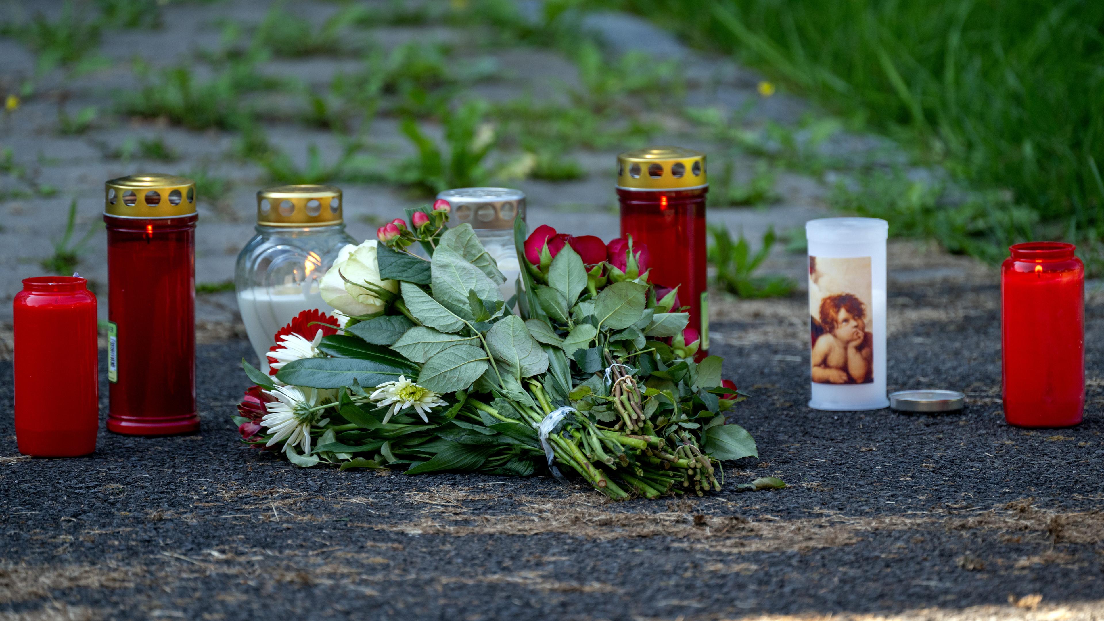 Kerzen und Blumen sind vor einem Seiteneingang des Schulzentrums in Lohr am Main abgelegt. (09.09.2023)