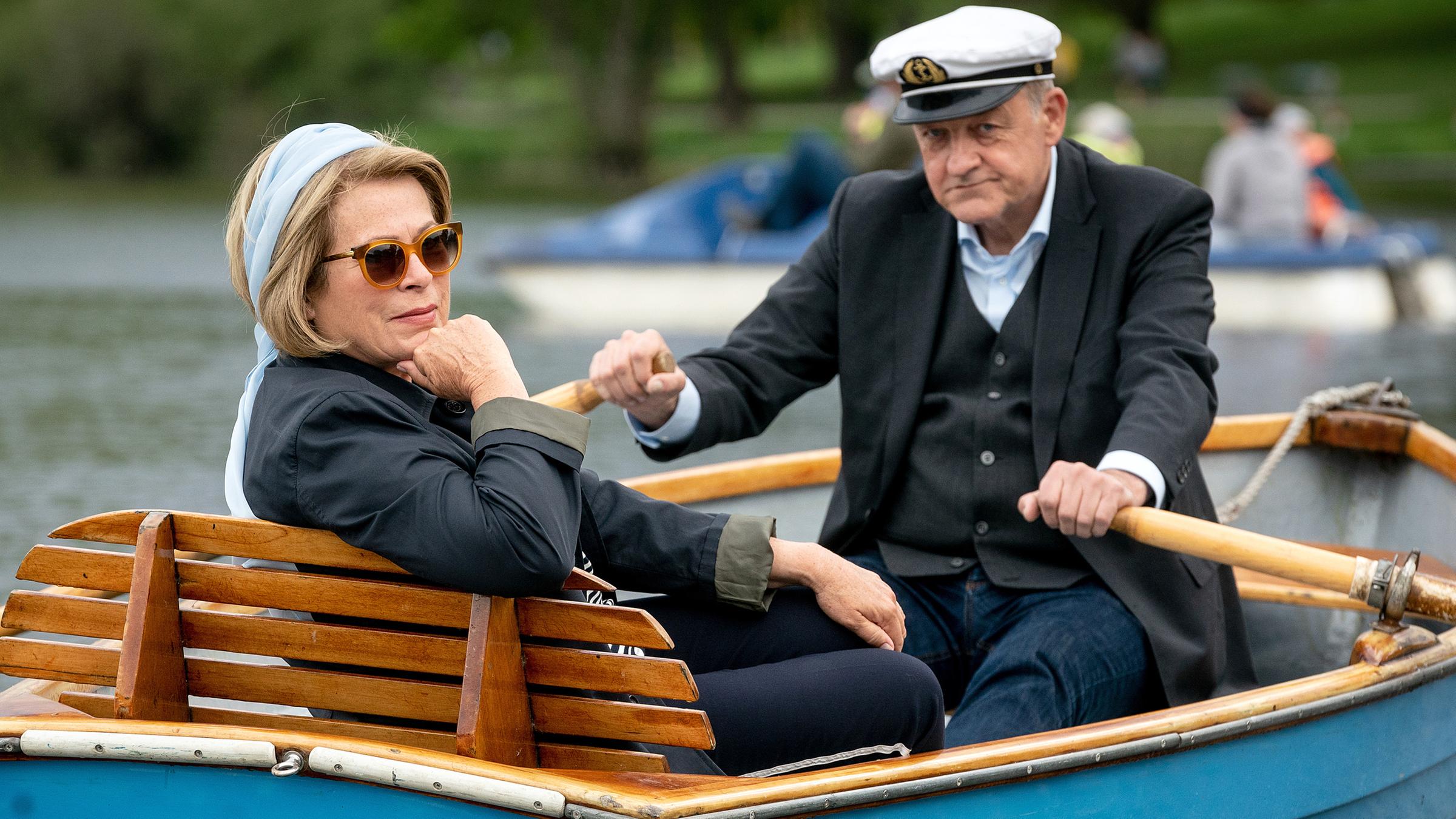 Anna Springer (Rita Russek) sitzt in einem Holzboot auf dem Aasee und überlässt Georg Wilsberg (Leonard Lansink) das Rudern.