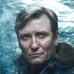 Alban (Oliver Masucci) vor einem Unter-Wasser-Hintergrund