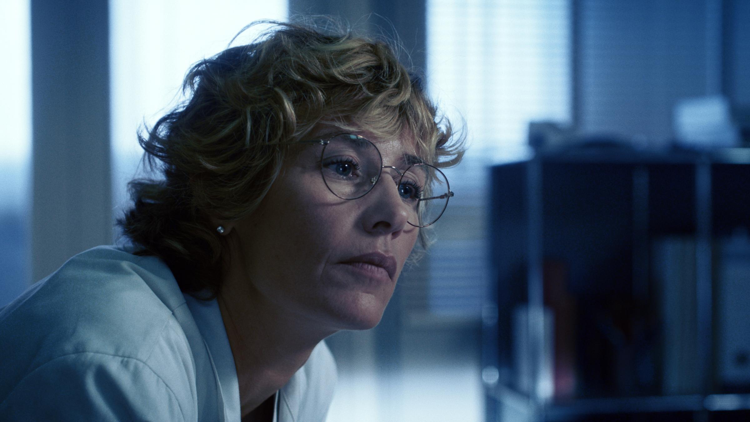 Dr. Cécile Roche (Cécile de France) sitzt nachdenklich in einem Büro, sie trägt einen weißen Kittel. 