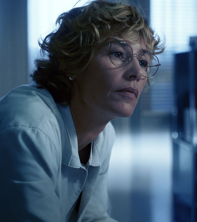 Dr. Cécile Roche (Cécile de France) sitzt nachdenklich in einem Büro, sie trägt einen weißen Kittel. 