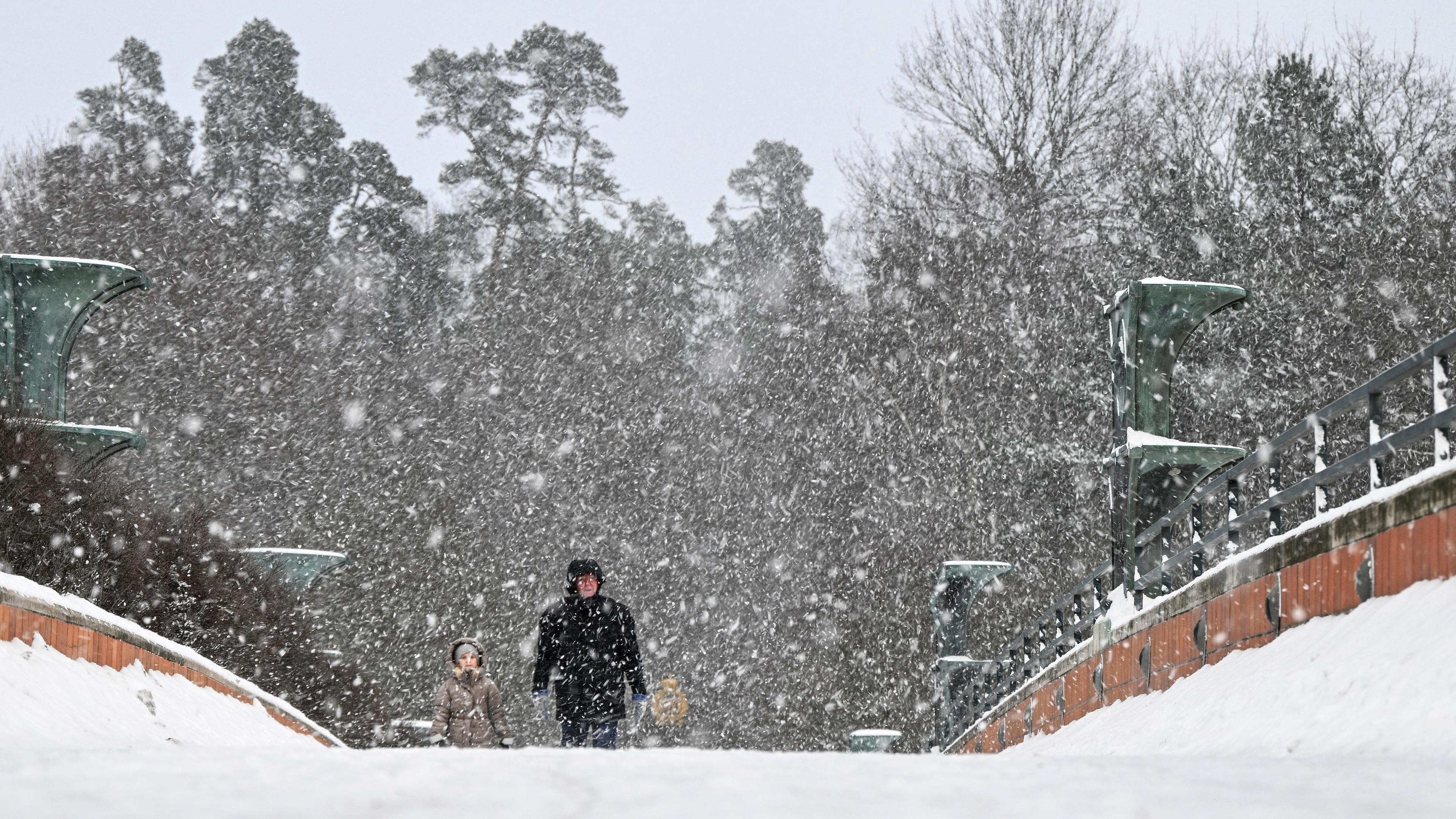 Schweden: Menschen gehen während eines Schneefalls in Stockholm spazieren