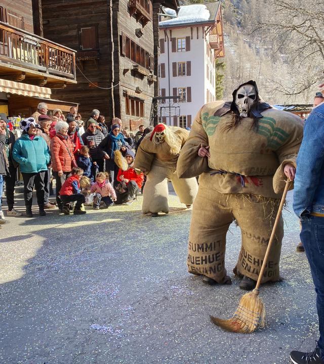 Carnaval d'Evolène, Umzug der Strohmänner. Am letzten Sonntag des Karnevals erwachen Strohriesen zum Leben, die im Dorf ihr Unwesen treiben.