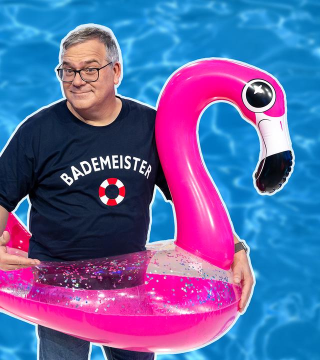 Elton trägt einen Schwimmreif in Form eines Flamingos.