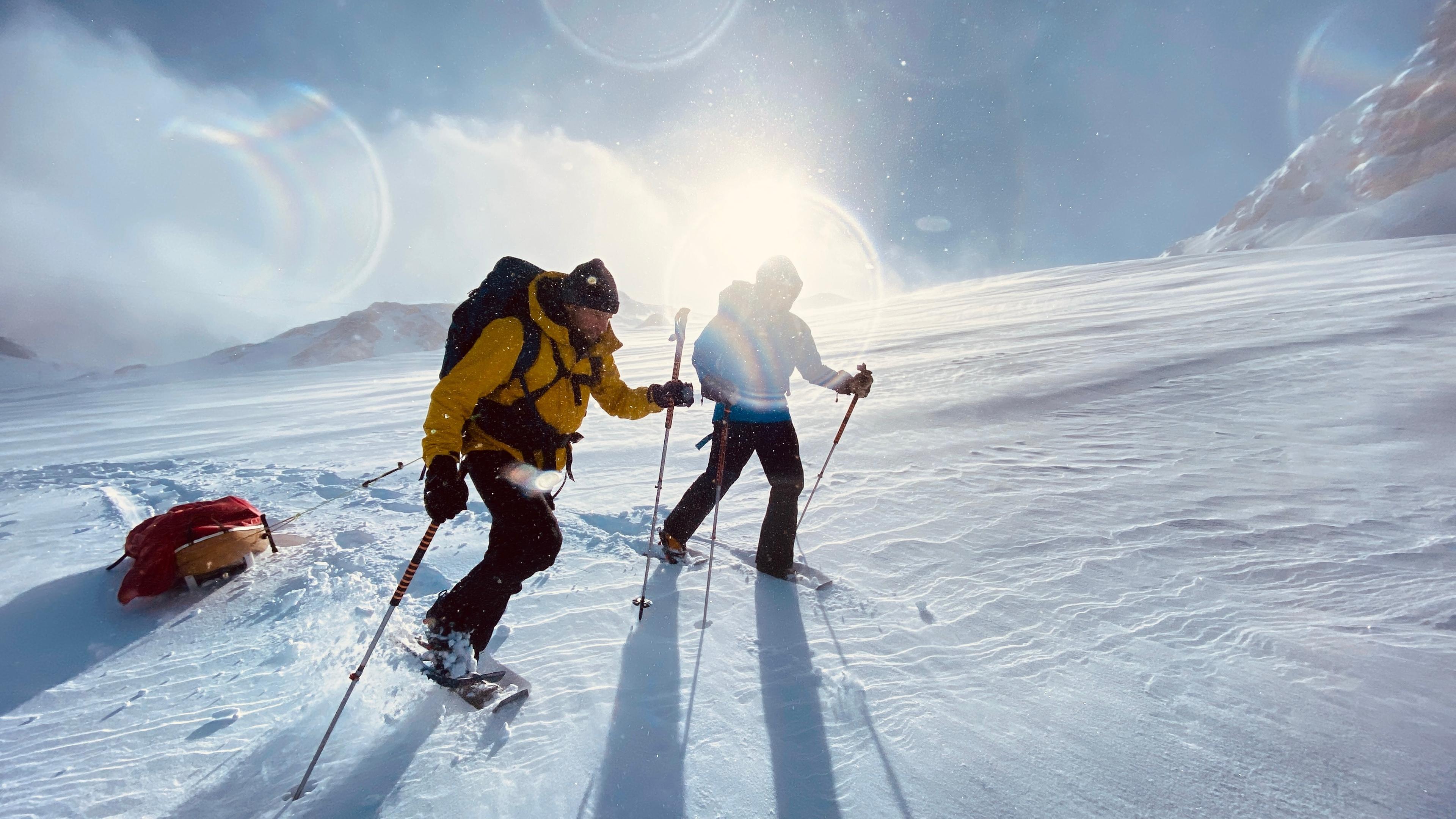 Sebastian Ströbel und Polarexperte Hans Honold ziehen eine Pulka durch eine traumhafte Schneelandschaft auf dem Dachstein.