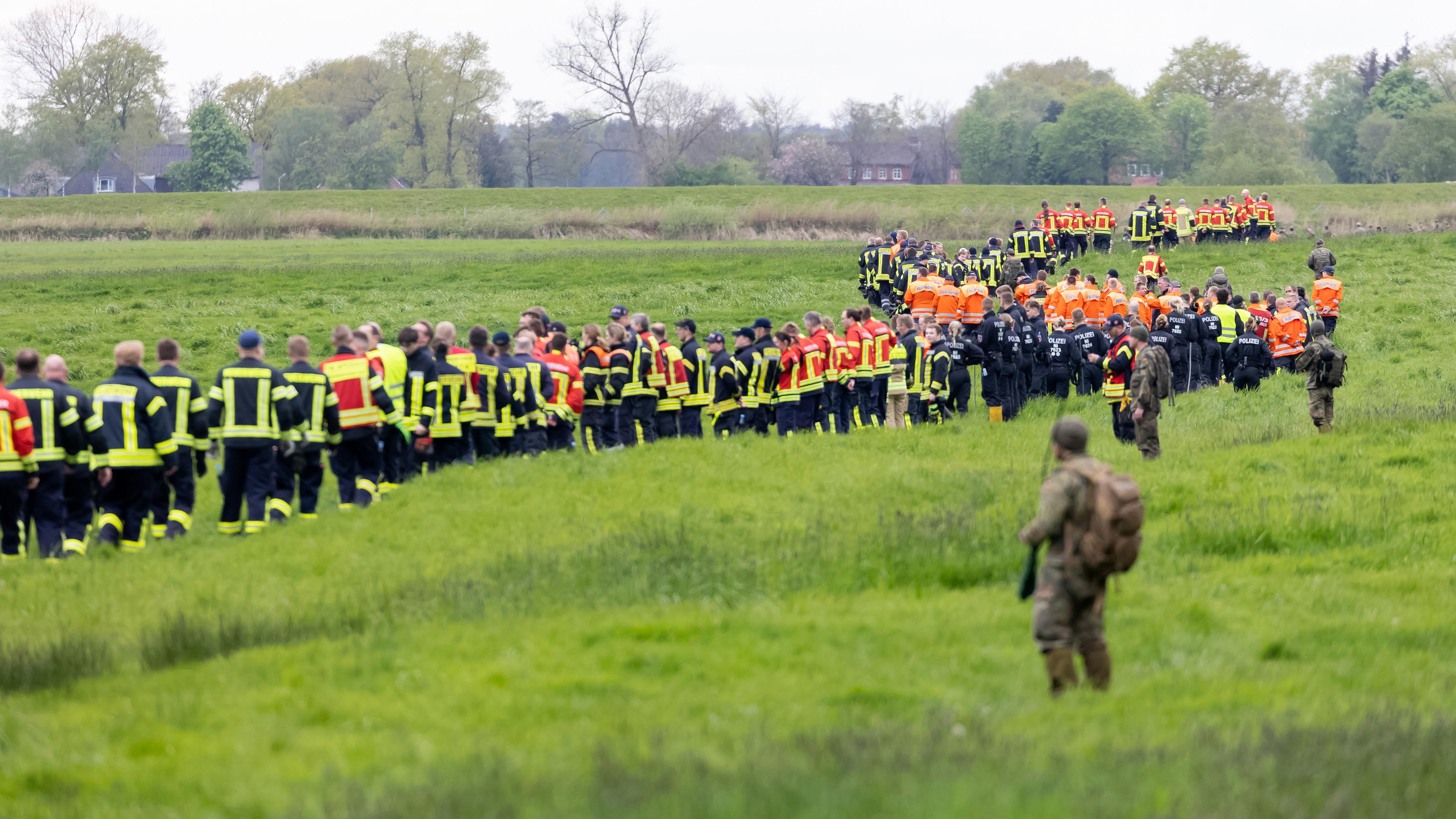 Niedersachsen, Gräpel: Soldaten der Bundeswehr und Einsatzkräfte von Feuerwehr und Polizei stellen sich auf, um ein Feld abzusuchen. 