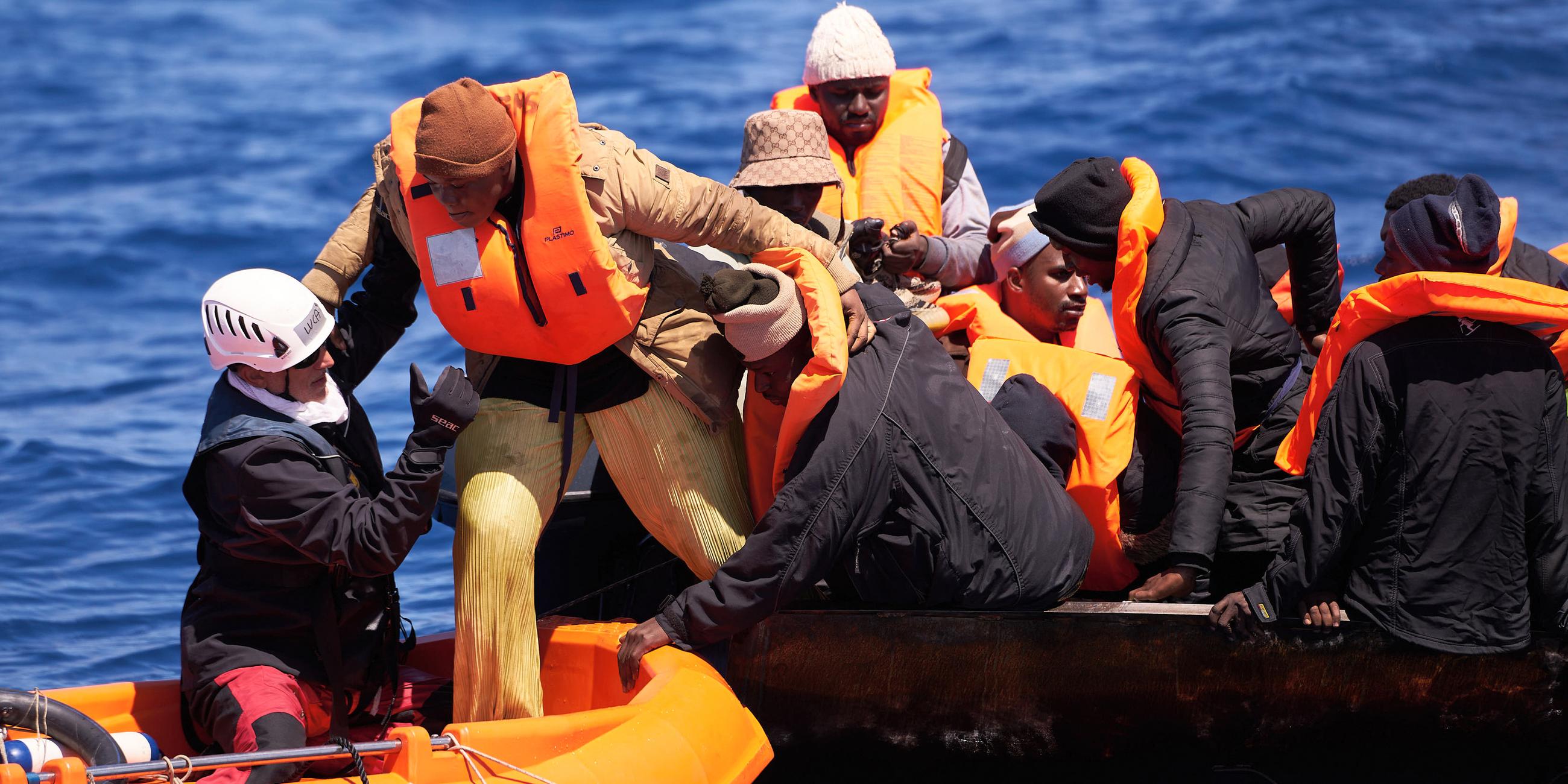 Mitglieder der Crew des Motorsegelschiffs "Nadir" helfen Migranten aus einem kentergefährdeten, überfüllten Stahlboot.