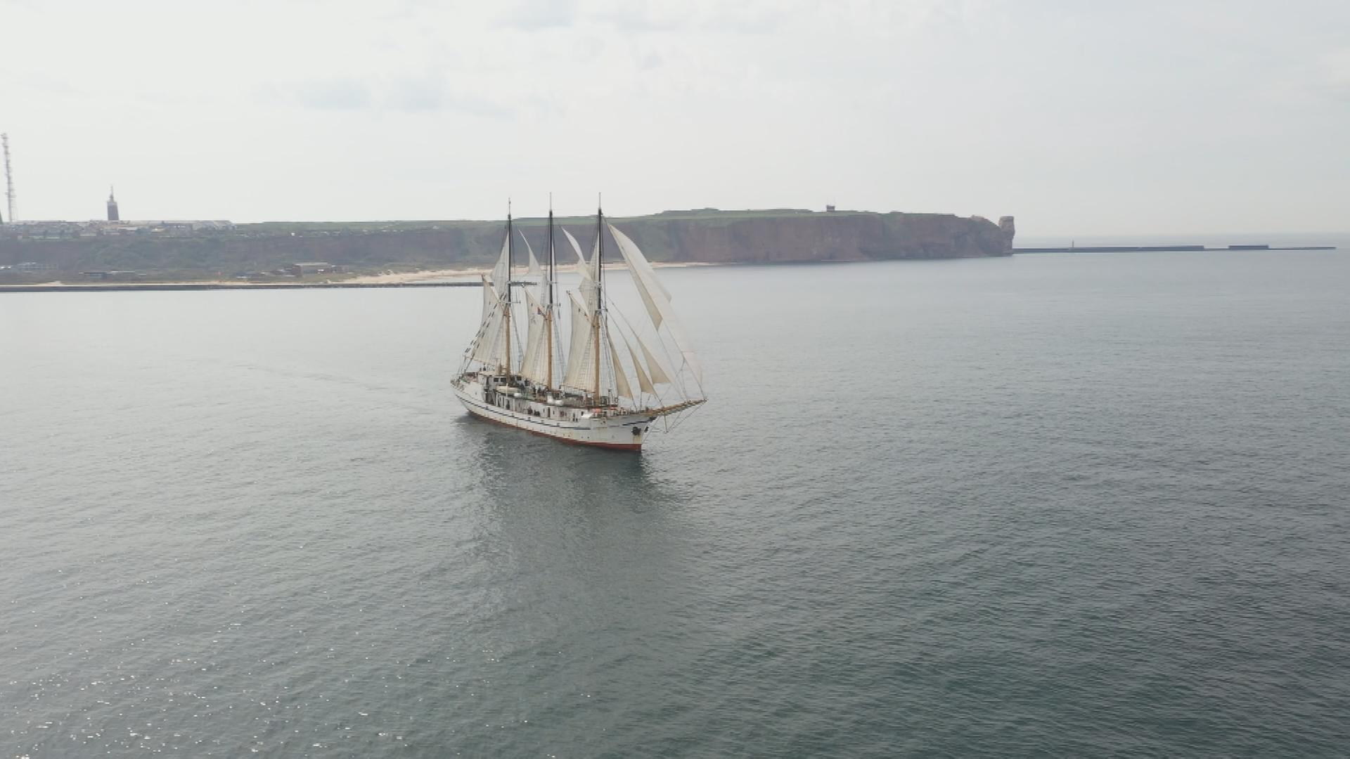 Auf dem Bild ist ein historisches Segelschiff auf dem Meer zu sehen.