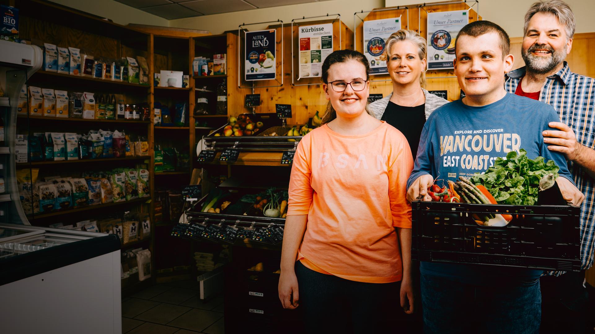 Claus und Sandra stehen hinter ihren Kindern, Marina und Lukas in ihrem Naturladen. 