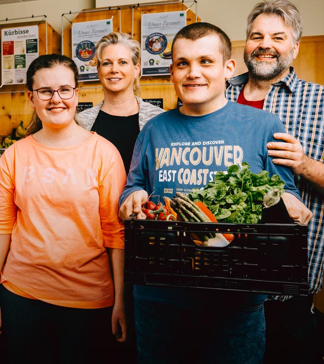 Claus und Sandra stehen hinter ihren Kindern, Marina und Lukas, in ihrem Naturladen. 