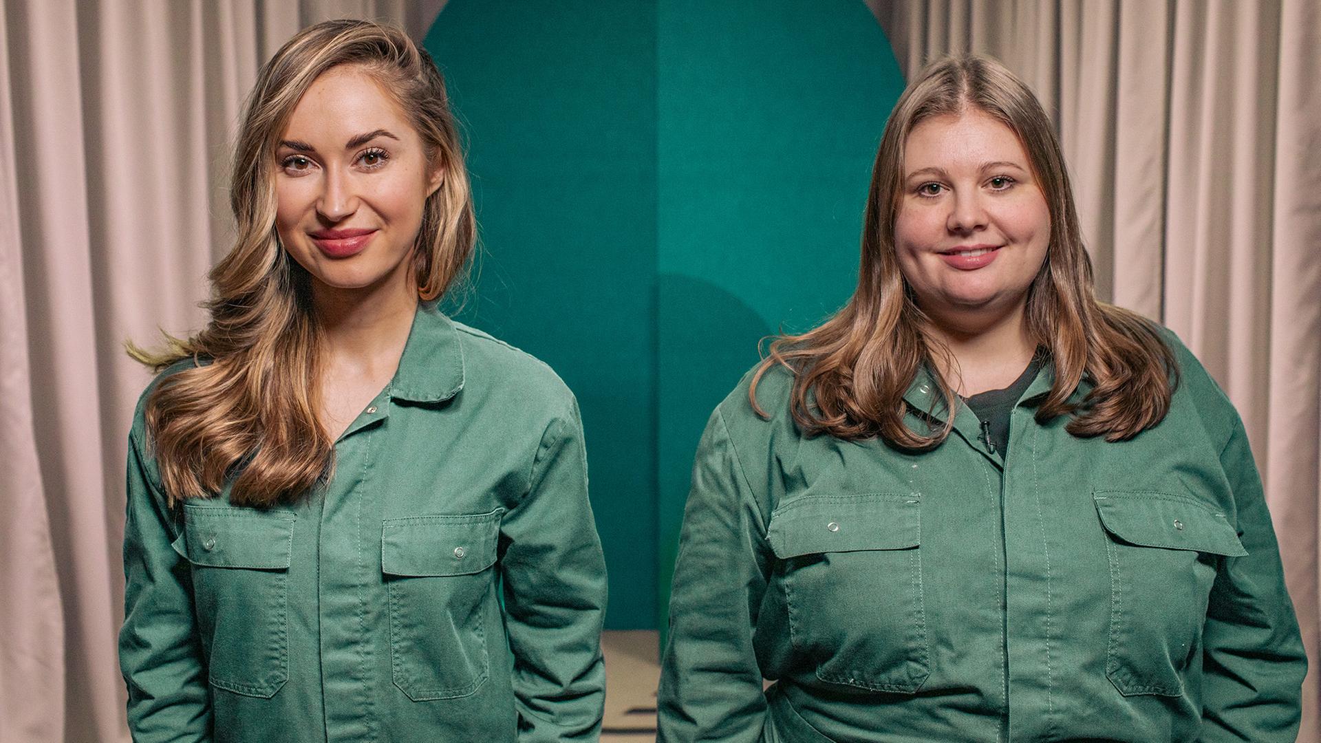Zwei Frauen blicken in die Kamera. Sie tragen beide den selben grünen Overall.