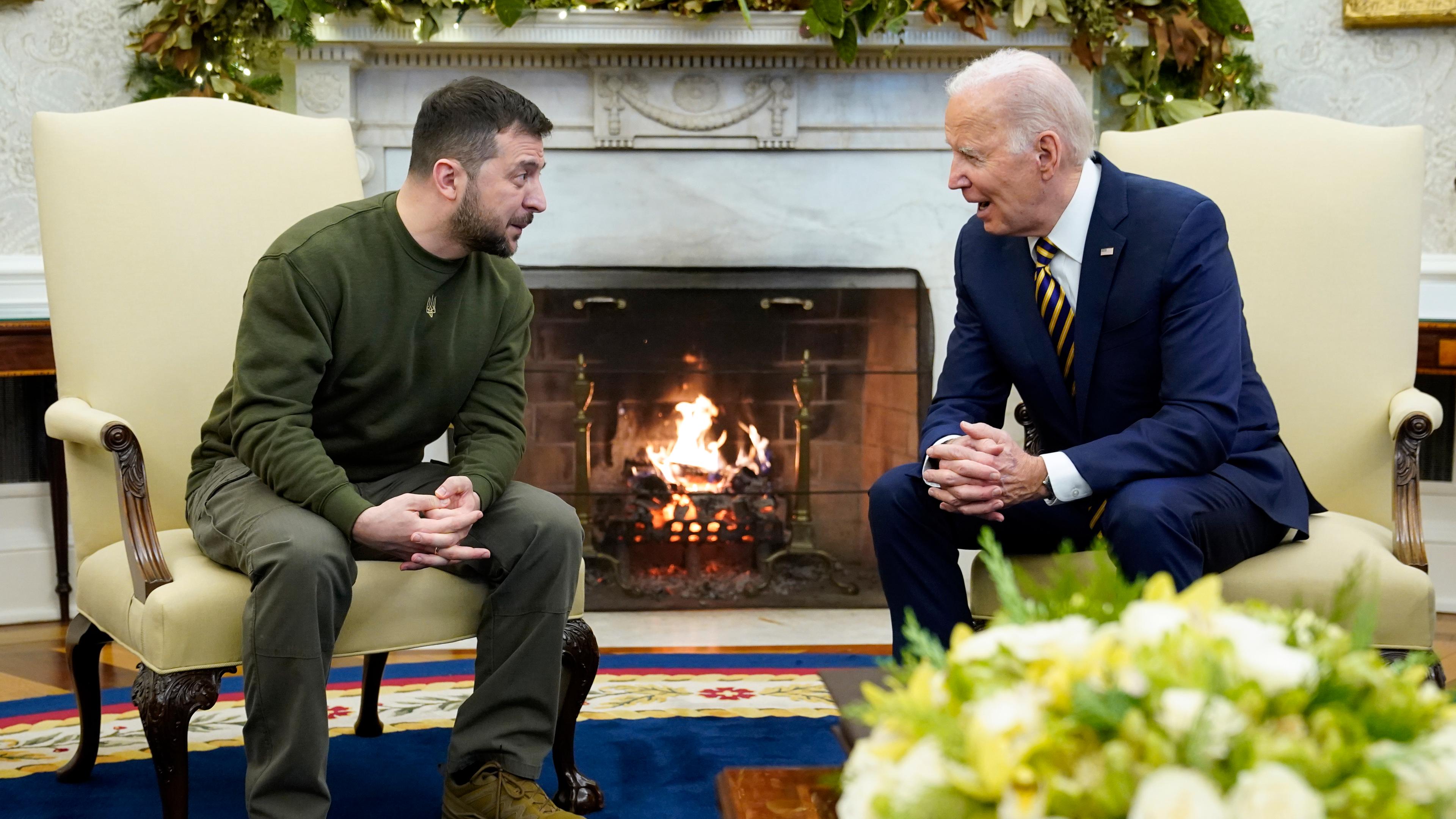 Der ukrainische Präsident Selenskyj sitzt neben seinem us-amerikanischen Amtskollegen in Sesseln vor einem Kamin. Sie unterhalten sich. 
