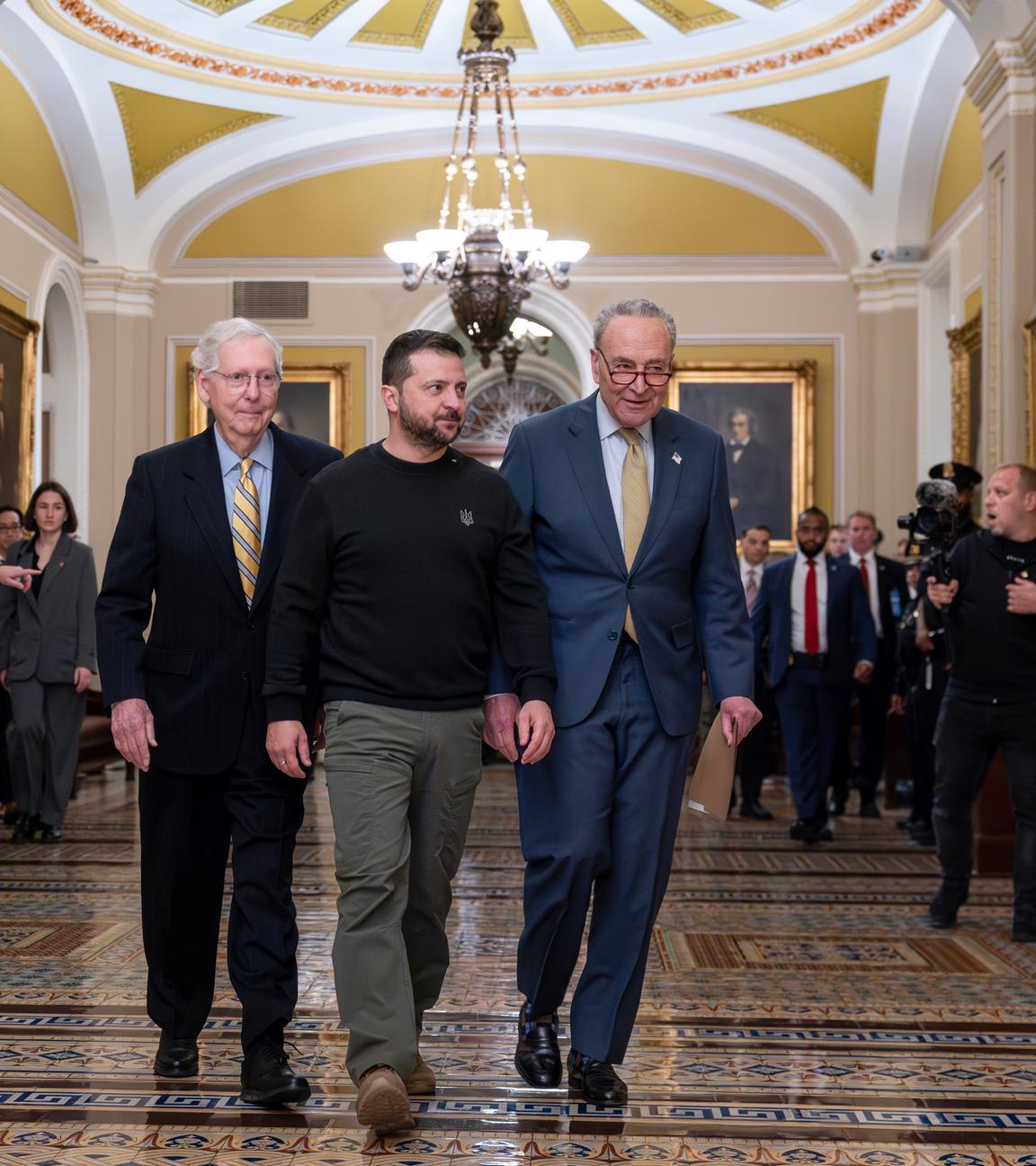 USA, Washington: Wolodymyr Selenskyj (M), Präsident der Ukraine, wird von Mitch McConnell (l), Minderheitsführer im Senat, und Chuck Schumer (r) , Mehrheitsführer im Senat, durch das Senatsgebäude begleitet, als er zum Kapitol in Washington ankommt.