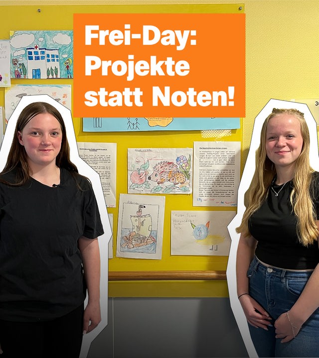Zwei Mädchen stehen vor einer großen Pinwand, an der Bilder und Schulplakat hängen und schauen stolz in die Kamera. Darüber der Schriftzug: "Frei-Day: Projekte statt Noten!"