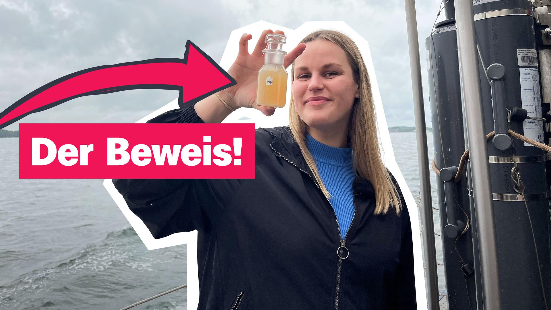 Ein Mädchen steht an der Reling eines Schiffs uns hält ein Glas mit einer orangenen Flüssigkeit in der Hand. Daneben der Schriftzug: "Der Beweis!"